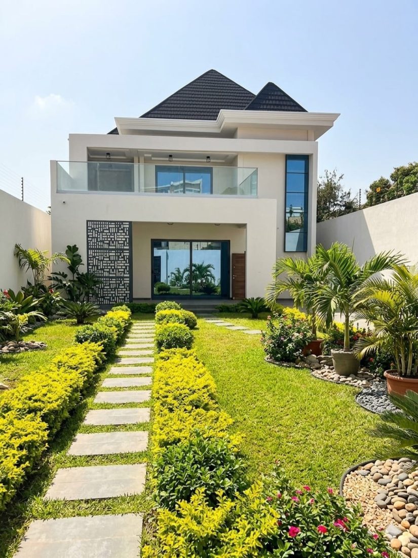 Villa blanche moderne avec allée de dalles et jardin entretenu